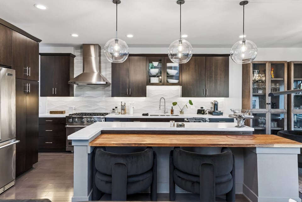 Modern kitchen with premium appliances, sleek finishes, and island seating for casual meals or morning coffee.