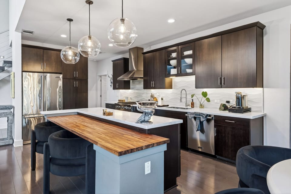 Modern kitchen with premium appliances, sleek finishes, and island seating for casual meals or morning coffee.