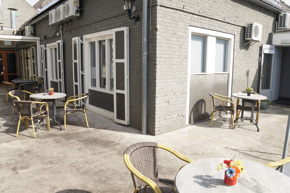 Sunny outdoor terrace with seating area, tables, and chairs, offering a relaxed space to enjoy fresh air and outdoor dining.
