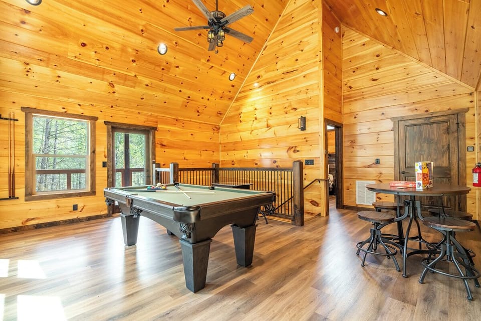 Your private game loft awaits with a full-size pool table and rustic pub seating, perfect for competitive evenings.