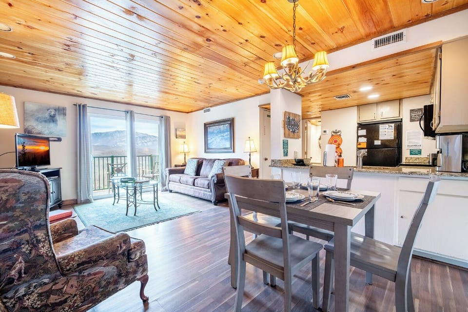 Gather around your rustic dining table while soaking in mountain views through expansive windows in this warm, wood-beamed space.