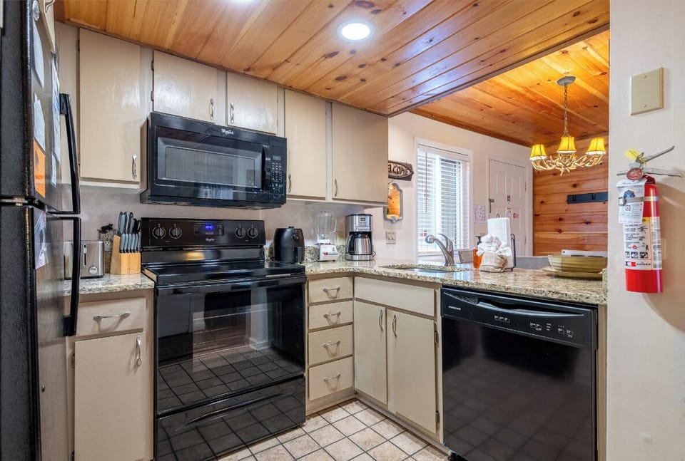 Your fully equipped kitchen awaits with modern appliances and granite counters, perfect for preparing meals in this cozy mountain retreat.