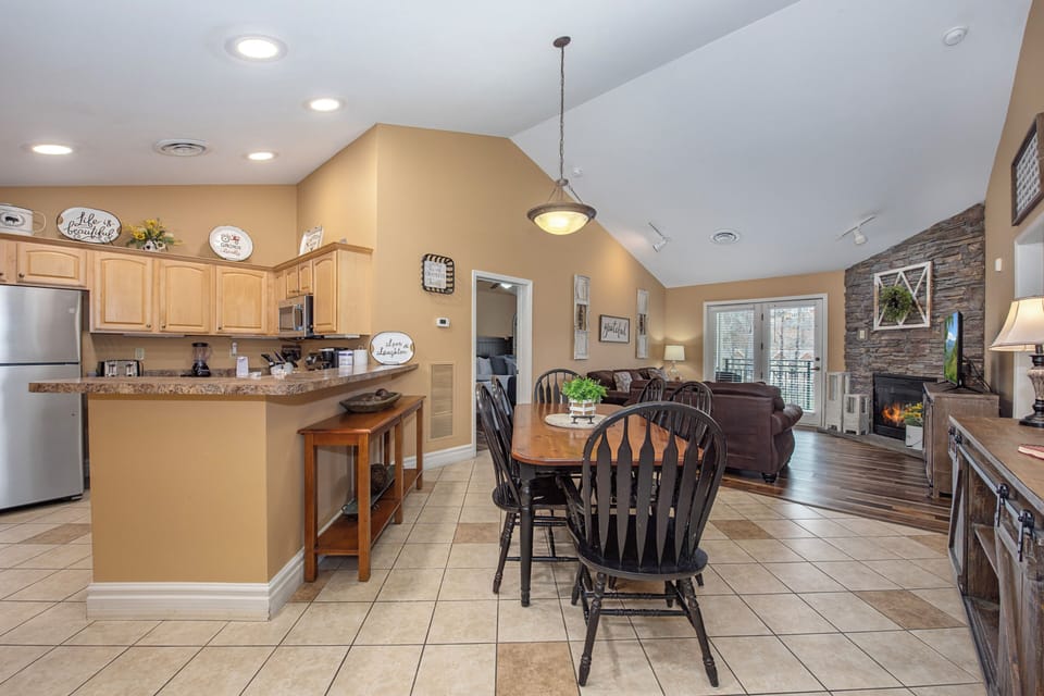 Gather around your spacious kitchen island for morning coffee, then relax by the stone fireplace in this beautifully designed open living space.