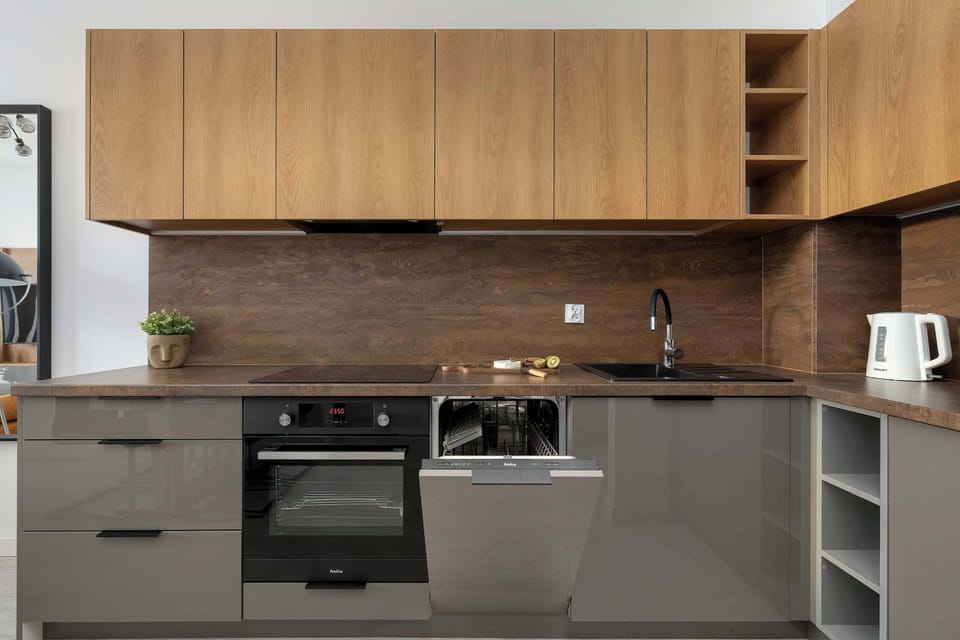 Another angle of a modern kitchen highlighting wooden cabinets and built-in cooking appliances.