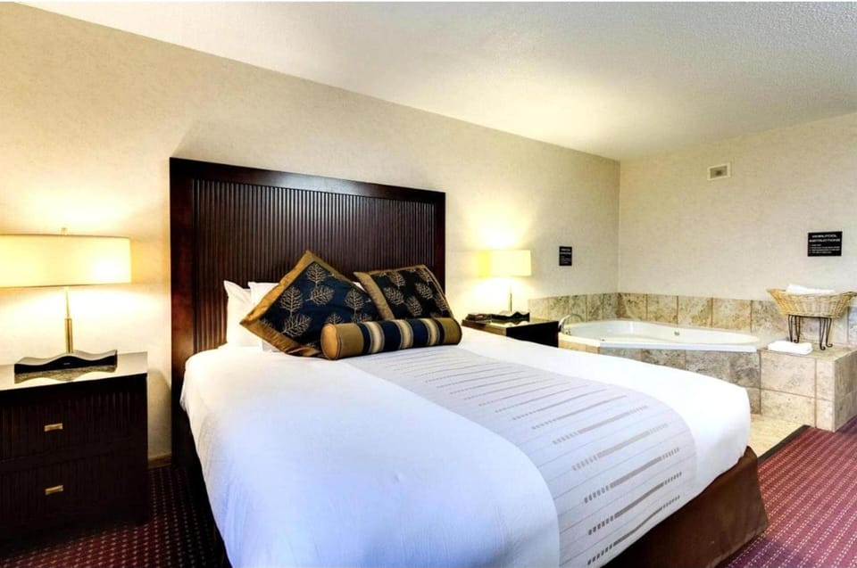 Sink into plush bedding beside your private whirlpool escape.