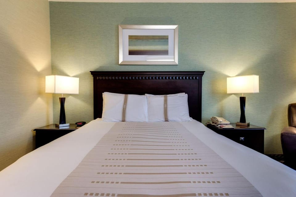 Sink into crisp linens under warm, restful bedside lighting.