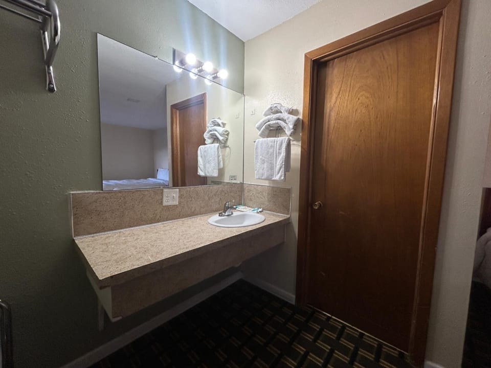 Freshen up at the bright vanity with plush towels.