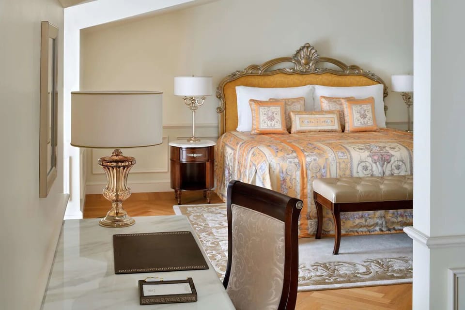 Sink into plush bedding beneath classic lamps and calming tones.