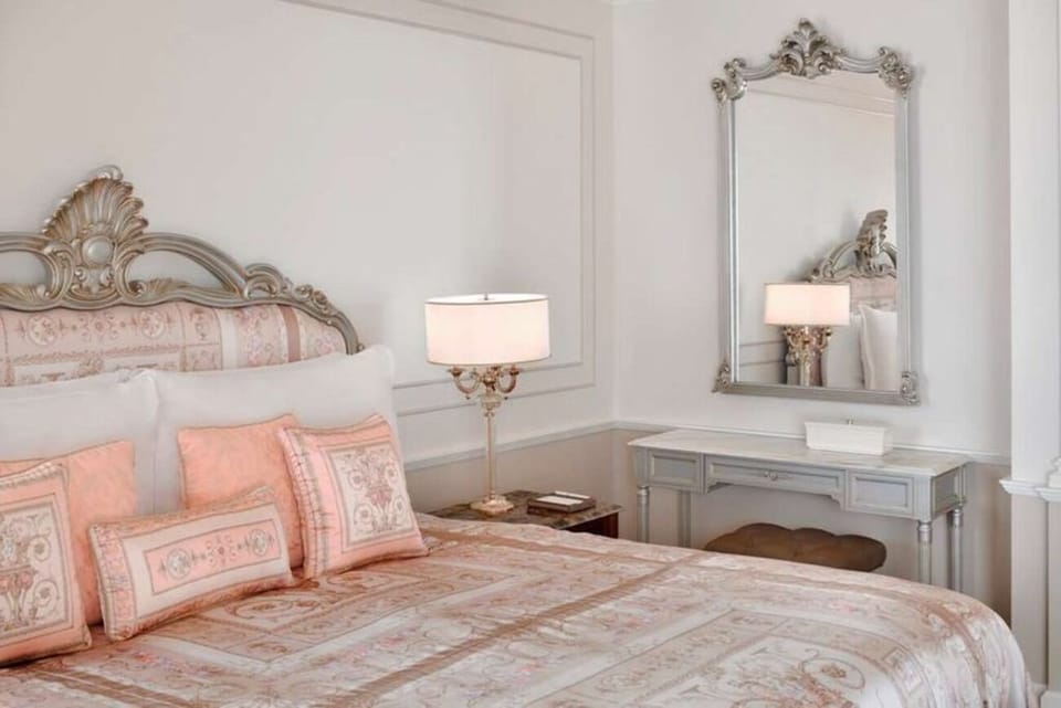 Sink into crisp linens beneath ornate, romantic headboard details.
