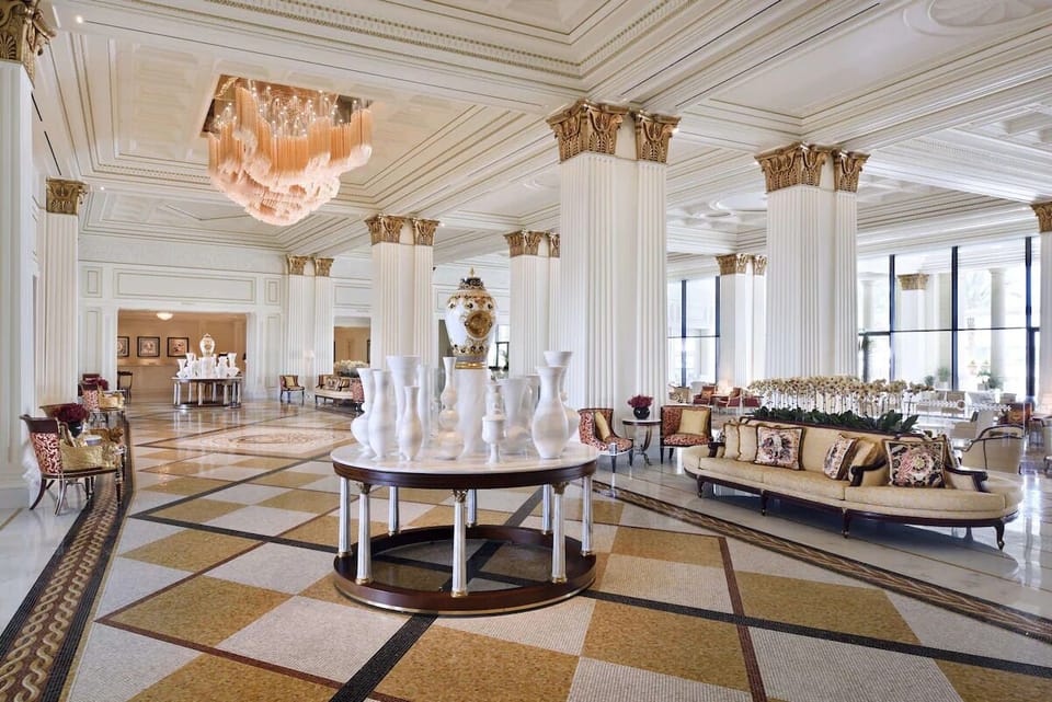 Step into a soaring lobby with palatial columns and light.