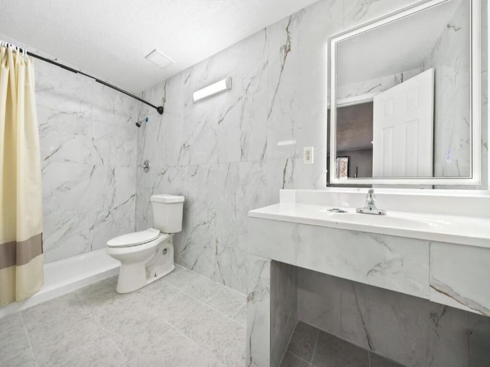 Refresh in a bright marble-style bath with roomy vanity.