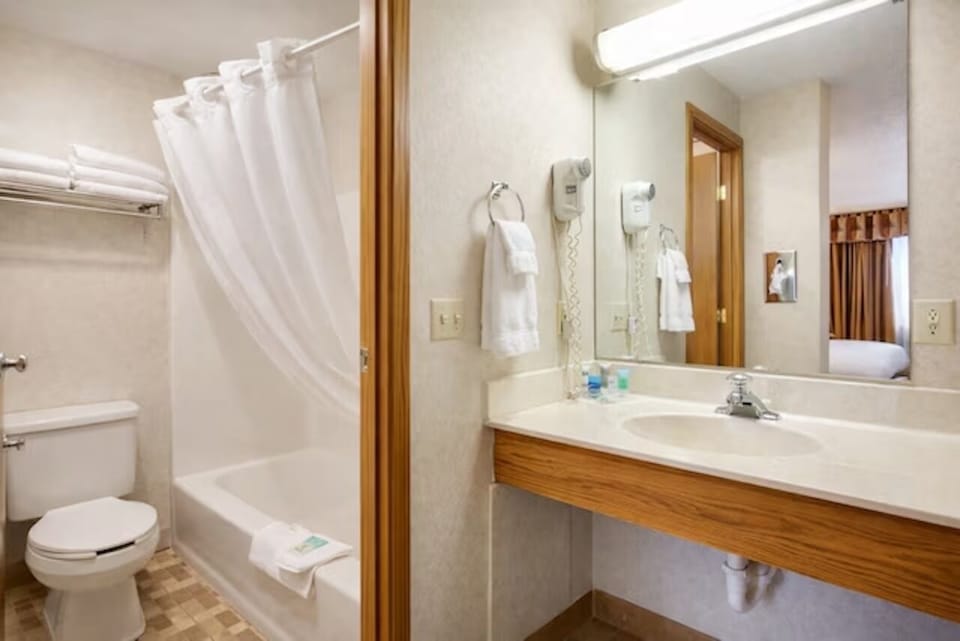 Get ready with a wide vanity, mirror, and fresh towels.