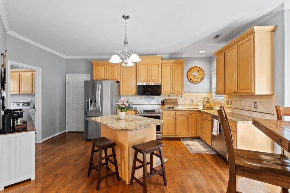 Bright and spacious kitchen with granite countertops, stainless steel appliances, and a convenient island with enough prep space to feed the entire family.
