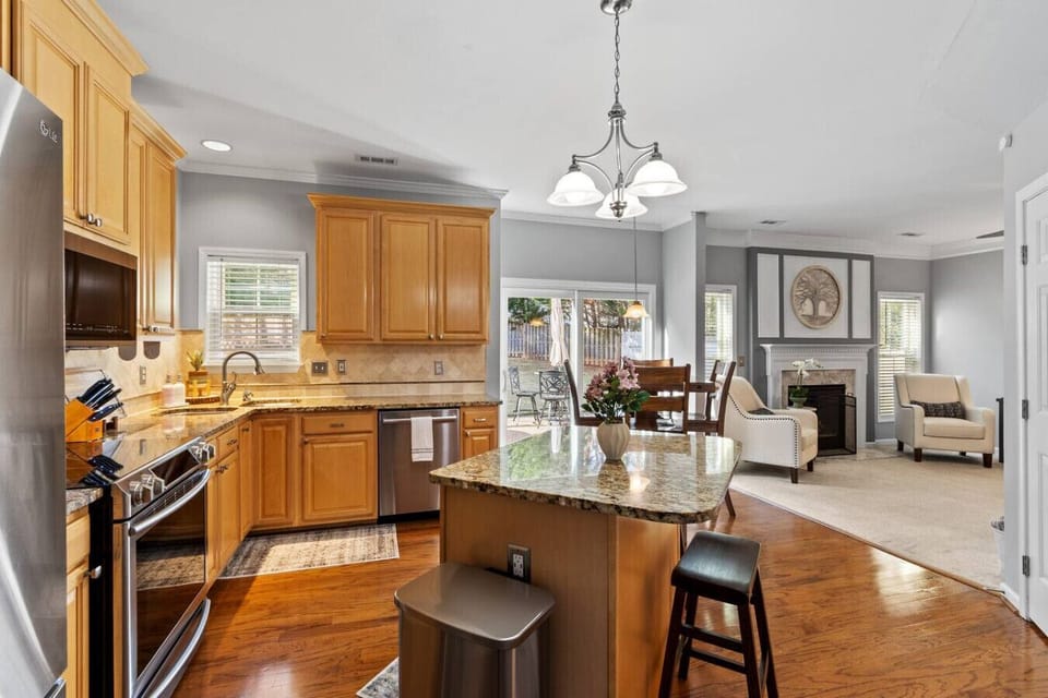 Our kitchen features granite countertops and island seating, and connects to the living room with an open floorplan.