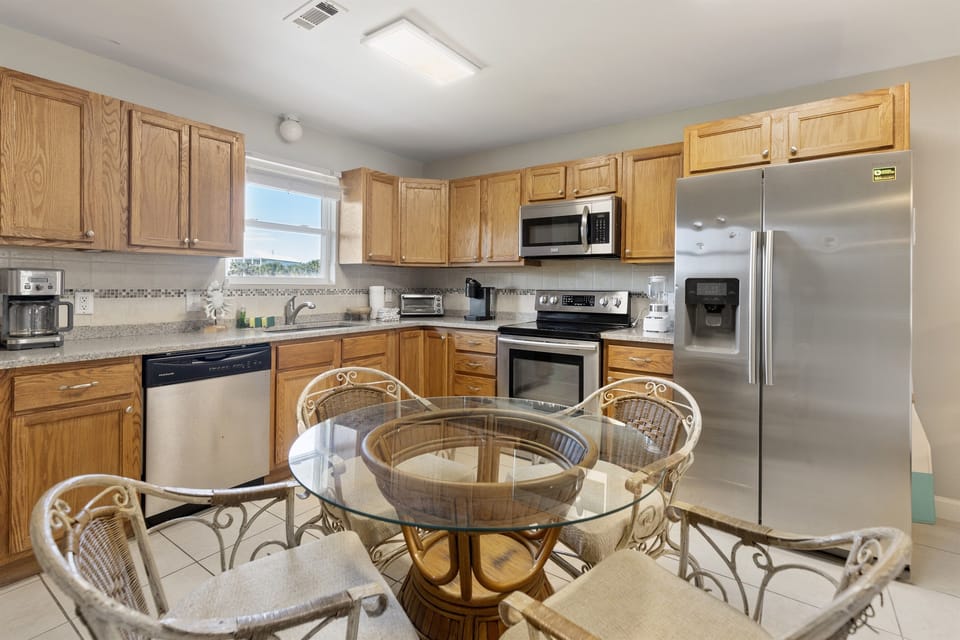 Cook your favorite meals in this fully equipped kitchen with stainless steel appliances and spacious granite countertops for easy meal prep.