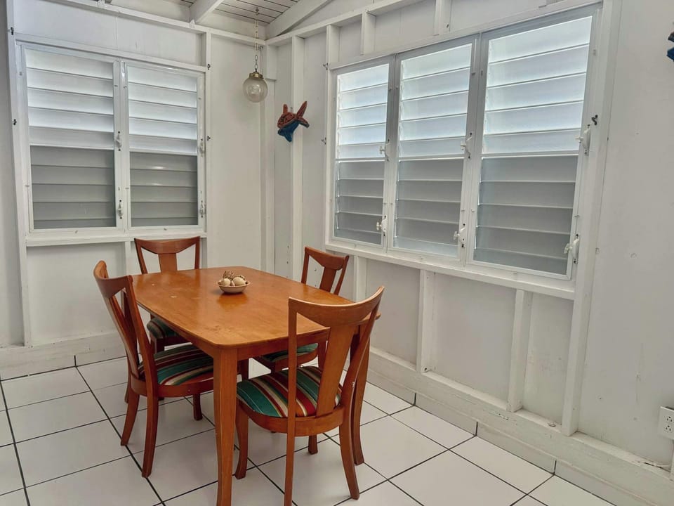 Bright and airy dining area with natural light streaming through louvered windows.