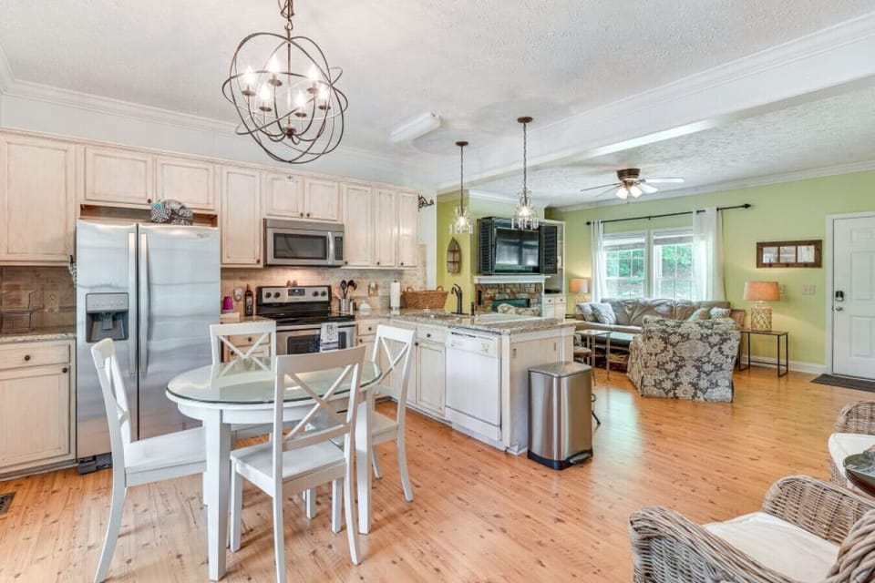 Dining Area | Round Table, Open Kitchen & Chandelier Lighting