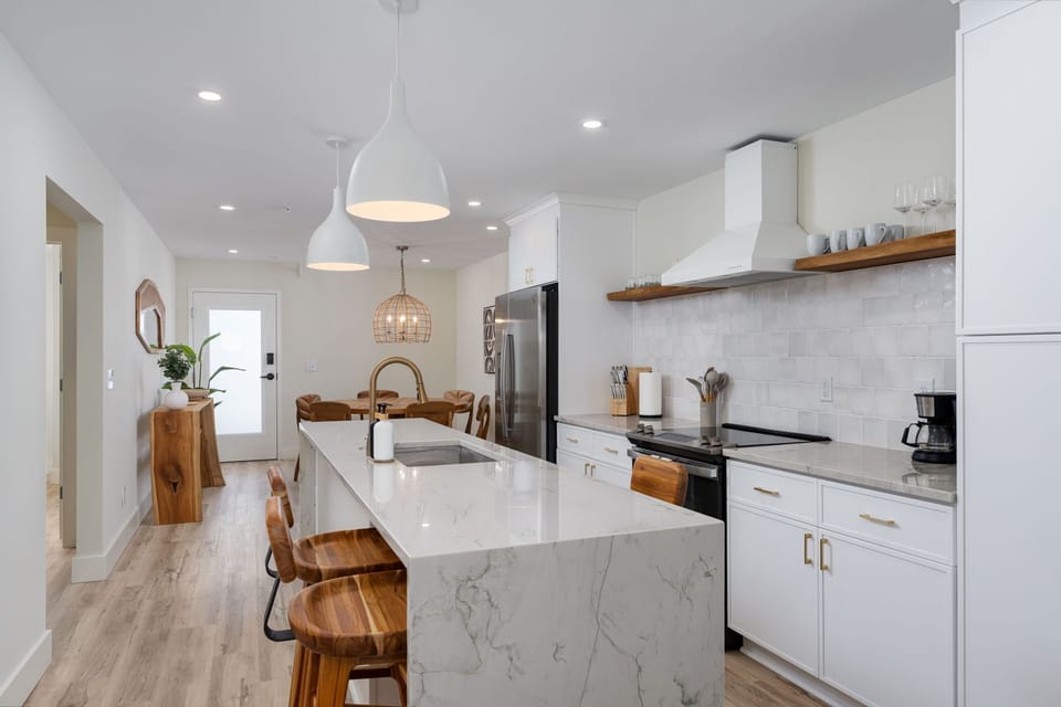 Your modern kitchen features marble countertops, premium appliances, and warm wood accents where you'll love preparing meals together.
