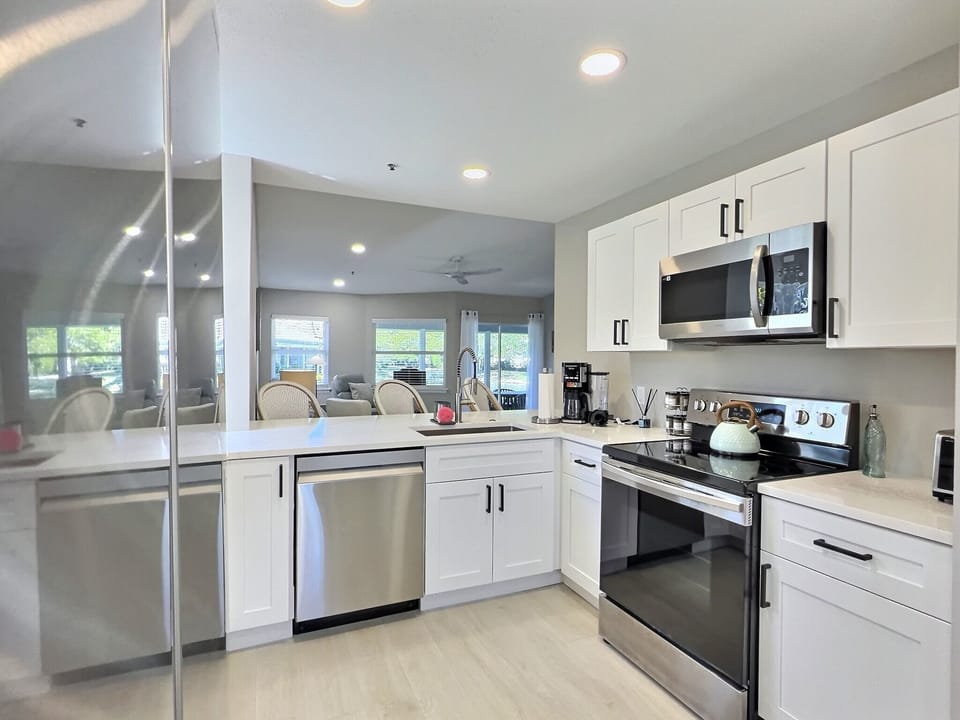 Kitchen with stainless steel range, microwave, and abundant cabinet storage in a bright open layout