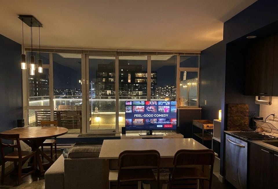 Open concept living and dining area with floor to ceiling windows.