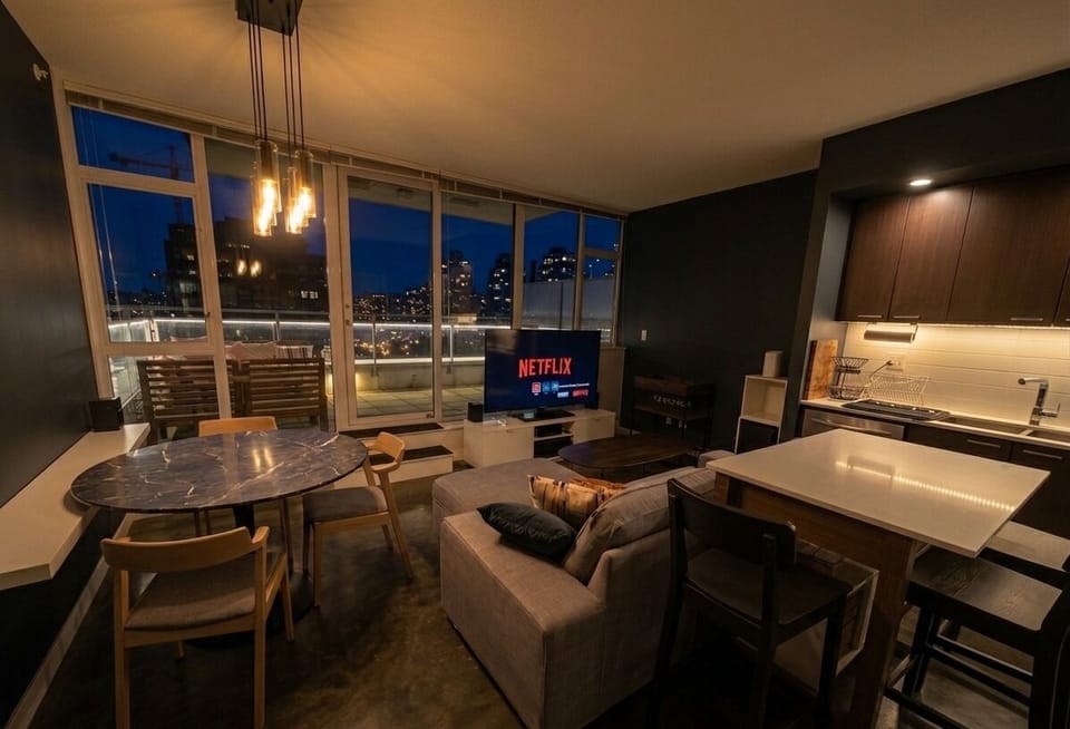 Open concept living and dining area with floor to ceiling windows.