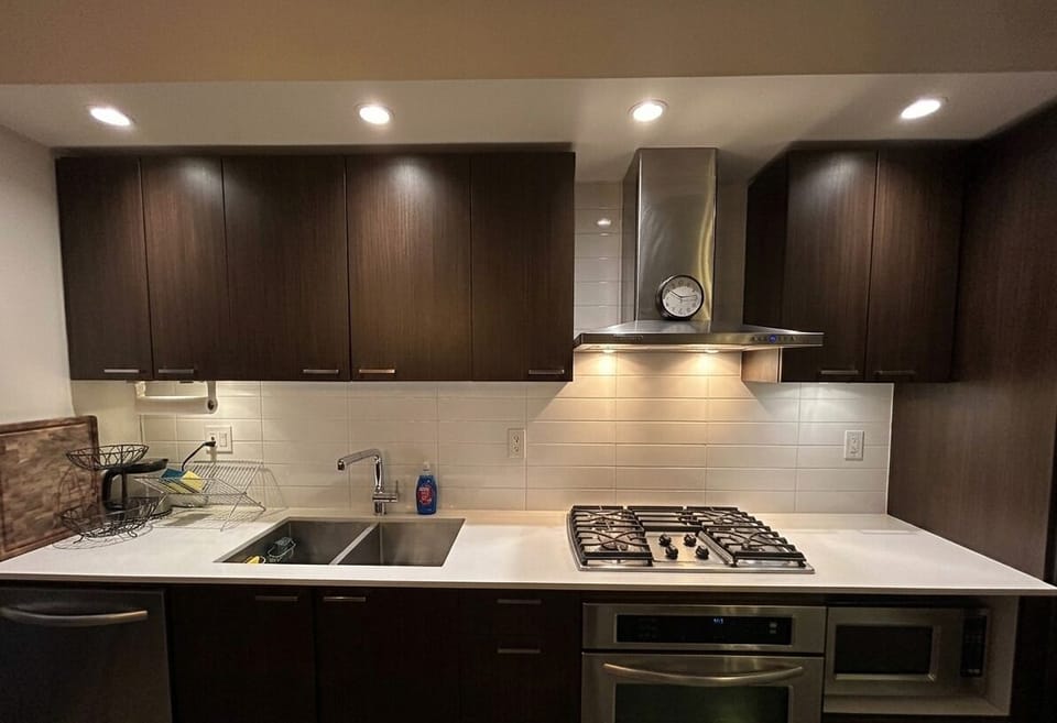 Modern kitchen with sleek cabinetry, gas stove and stainless steel appliances.