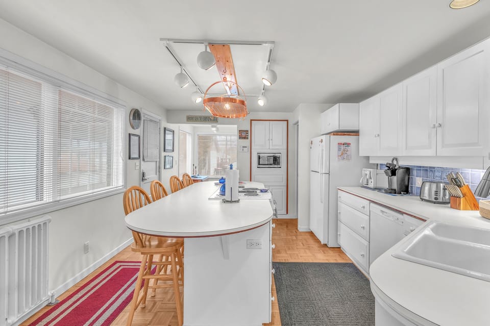 Your bright, well-equipped kitchen invites you to prepare meals together, featuring modern appliances and a spacious dining table for memorable gatherings.