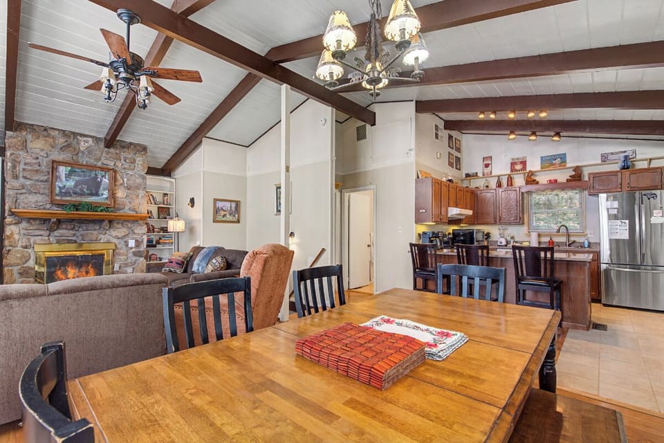 Gather around the rustic dining table while the fireplace crackles nearby, creating the perfect mountain retreat atmosphere for your memorable meals.