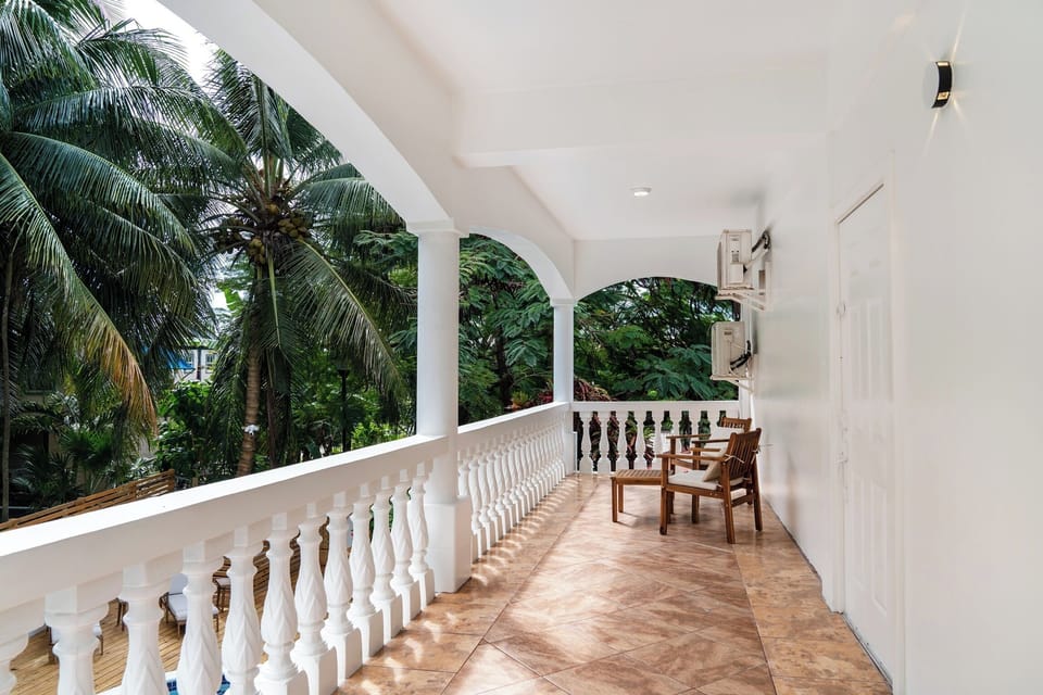 Relax in your private covered balcony with tropical garden views and comfortable seating