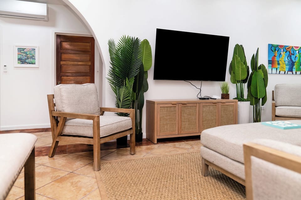 Unwind in your stylish living room with natural textures, lush plants, and modern entertainment for perfect relaxation.