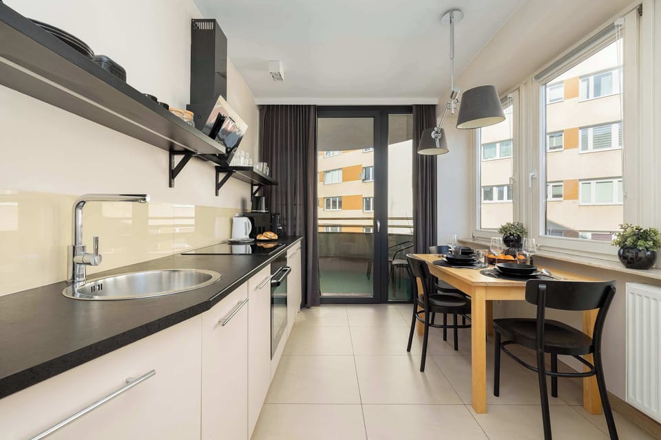 A long kitchen with modern cabinets and a dining area at the end. The layout maximizes space while maintaining functionality.