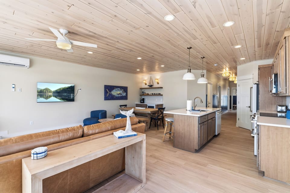 Spacious open concept living area with vaulted wood ceiling and kitchen island