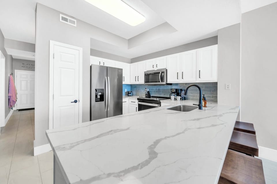 Step into your sleek modern kitchen with gleaming marble counters, stainless steel appliances, and bright skylights overhead for effortless meal prep.