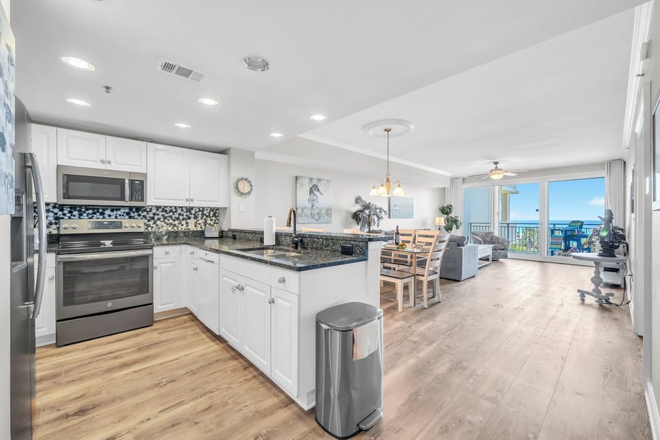 Your stunning oceanfront condo features gleaming granite counters and stainless appliances, flowing seamlessly into the living area where Gulf views await.