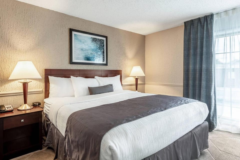 Sink into a plush king bed under warm bedside lighting.