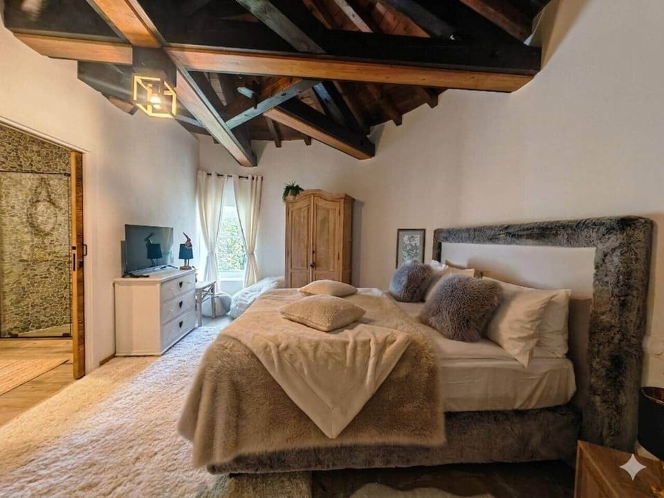 Bedroom with exposed beams and a king bed, designed for a calm and restful stay