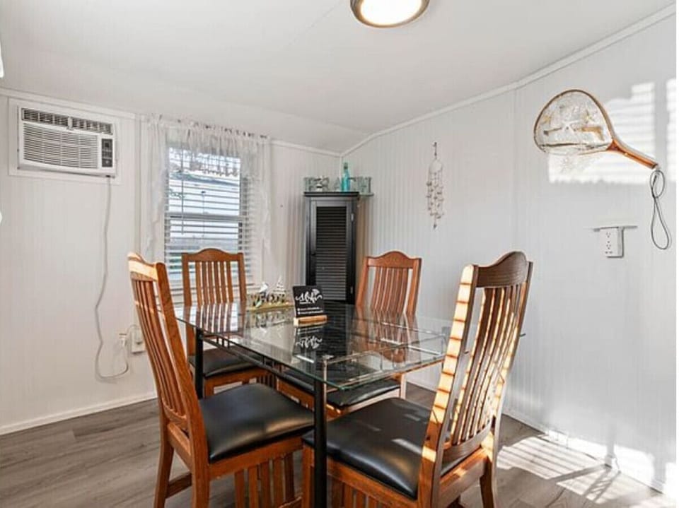 Dining Area | Wood Chairs | Wall AC Unit & Window Coverings