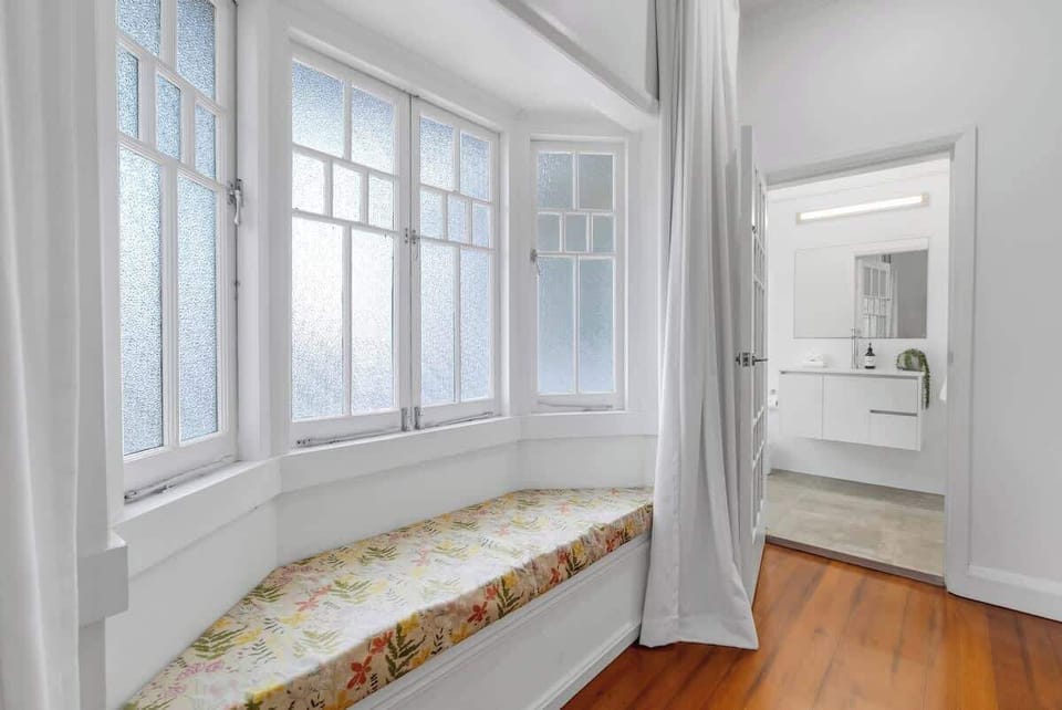 Settle into the bay window seat in the primary bedroom, a quiet nook perfect for reading or enjoying soft natural light.