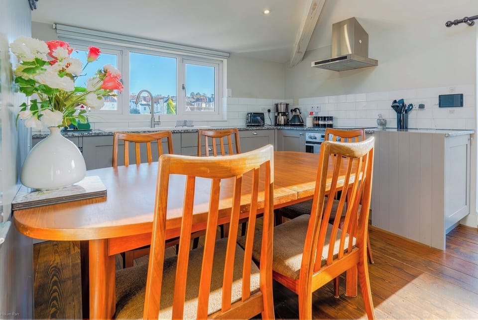 Dining area with table, chairs, and fully equipped kitchen