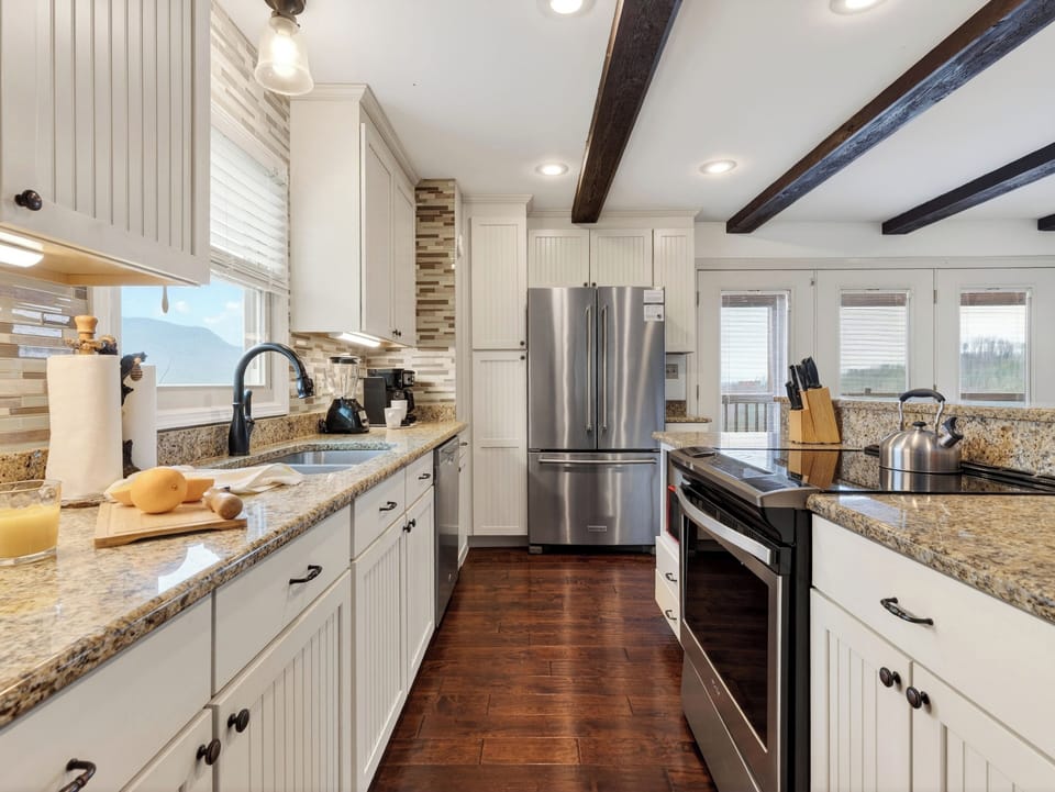 Fully equipped kitchen with stainless steel appliances and white cabinetry.