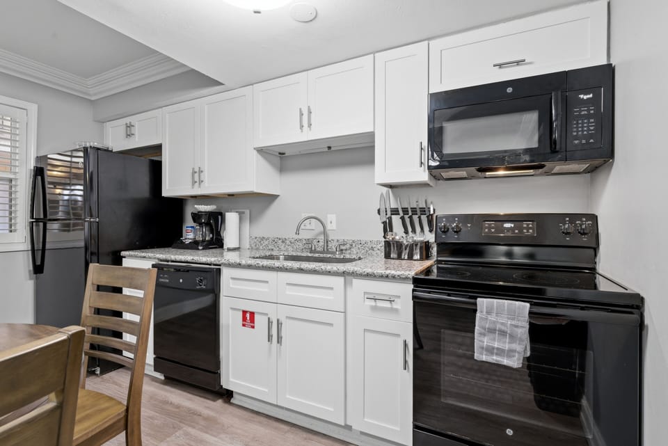 Sleek white kitchen fully equipped for cooking in
