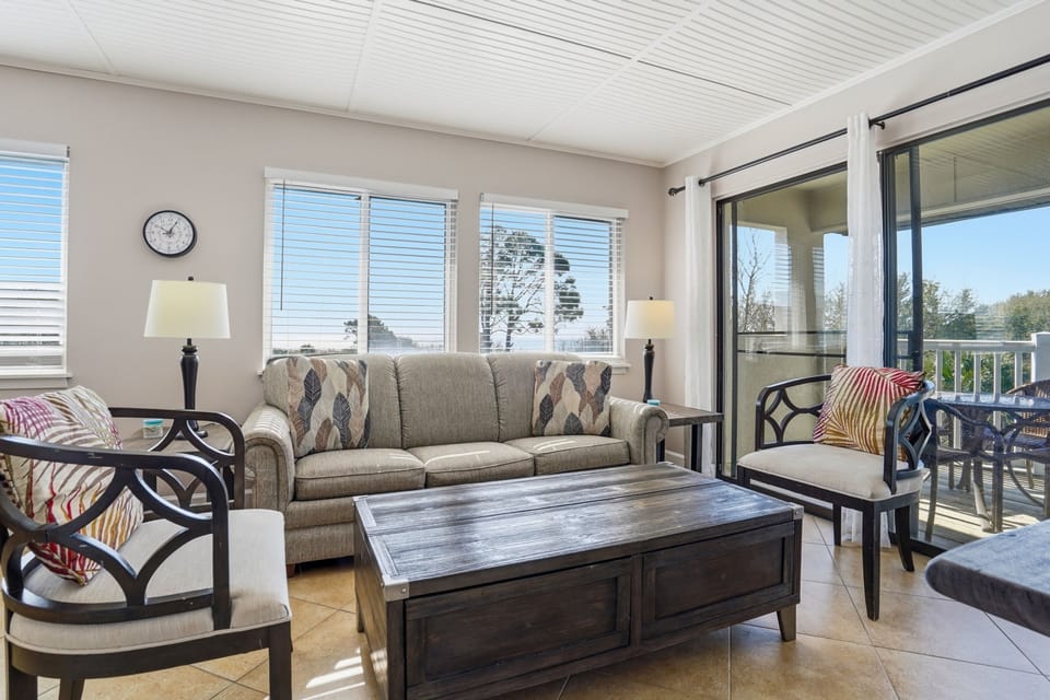 Open Living Area with Balcony Access – Shipwatch 300 - Comfortable seating and natural light create an easy flow between the indoor space and the outdoor balcony.