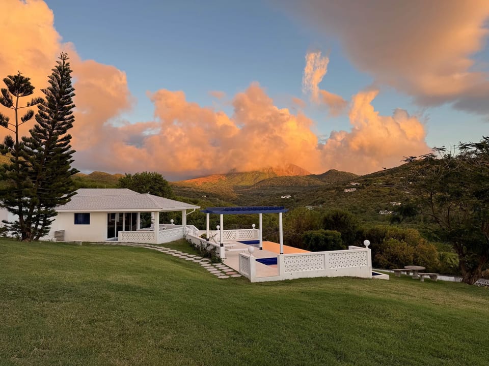 Roadside view of the villa, showcasing its modern architecture, inviting entrance & beautifully