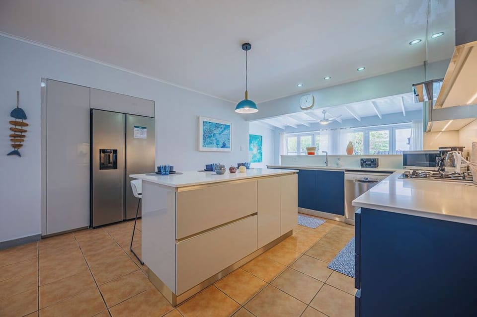 This open-concept kitchen showcases a stunning blue and white design, complemented by a central island perfect for both entertaining and everyday comfort.