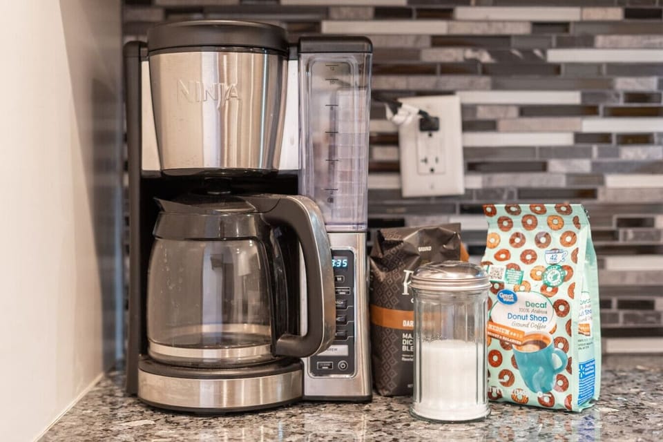 The fully equipped kitchen is ready for anything, featuring an electric stove, microwave, dishwasher, oven, coffee maker, blender, and electric kettle.