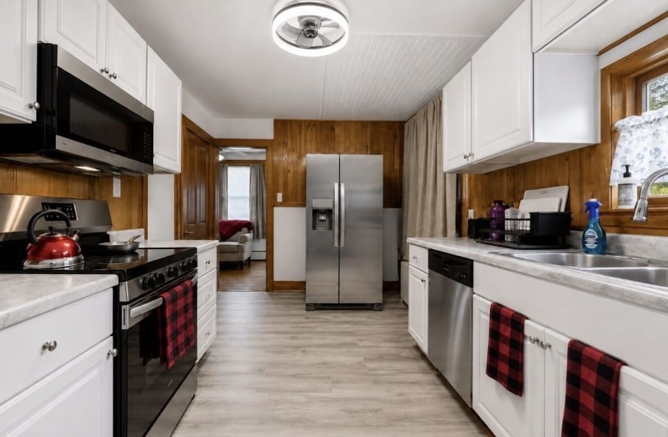 Kitchen has new (2025) stainless steel fridge with ice/water, stainless steel oven w/smooth-top range, stainless steel microwave & dishwasher. Cookware, knives, blender, wine glasses, toaster, rice&slow-cooker.