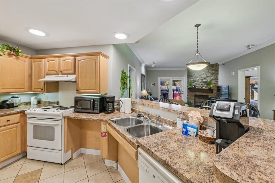 Your fully-equipped kitchen features granite countertops, warm wood cabinetry, and modern appliances, perfect for preparing memorable meals during your stay.