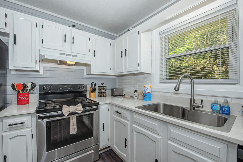 Your fully equipped kitchen features crisp white cabinets, stainless steel appliances, and everything you need for home-cooked meals.