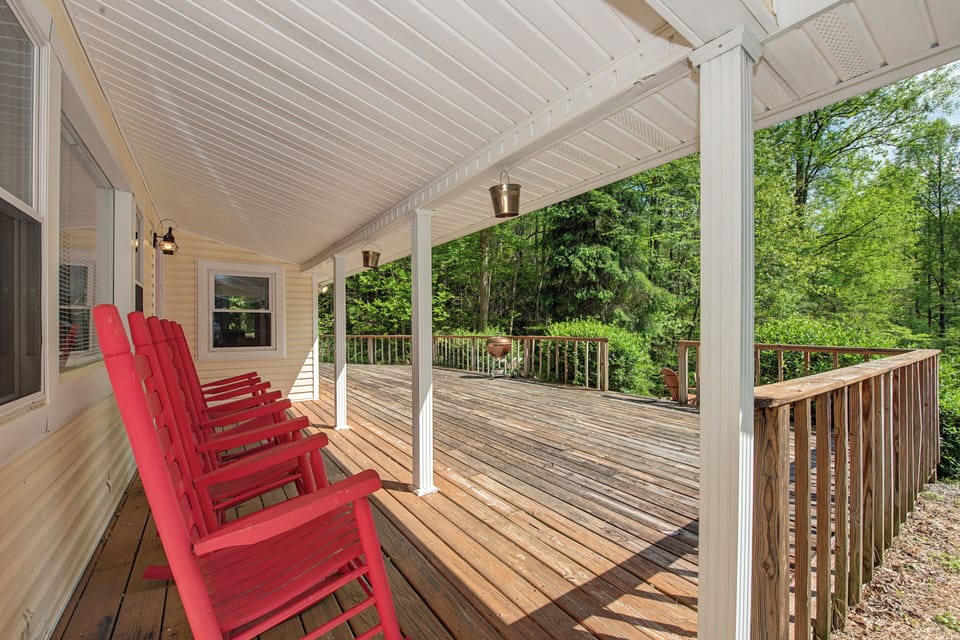 Your private covered deck awaits with comfy red chairs for morning coffee and peaceful forest views.