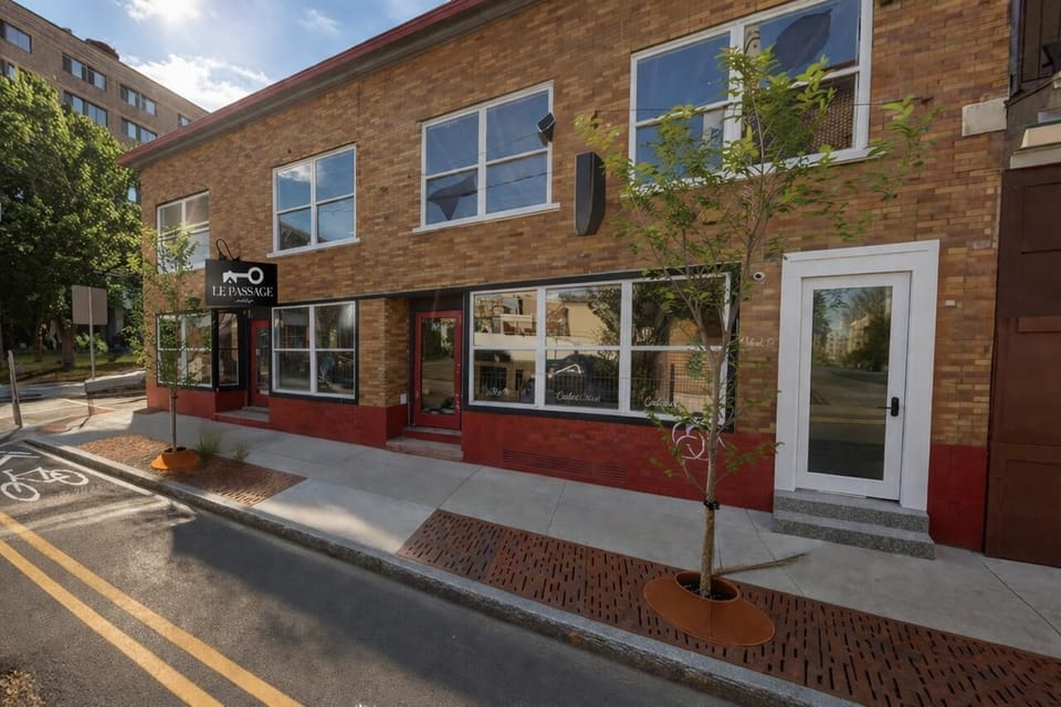 Extérieur : Façade en briques éclatantes avec de grandes fenêtres ; flânez dans les charmantes rues de Québec !